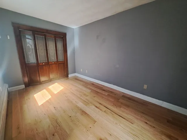 a view of empty room with wooden floor