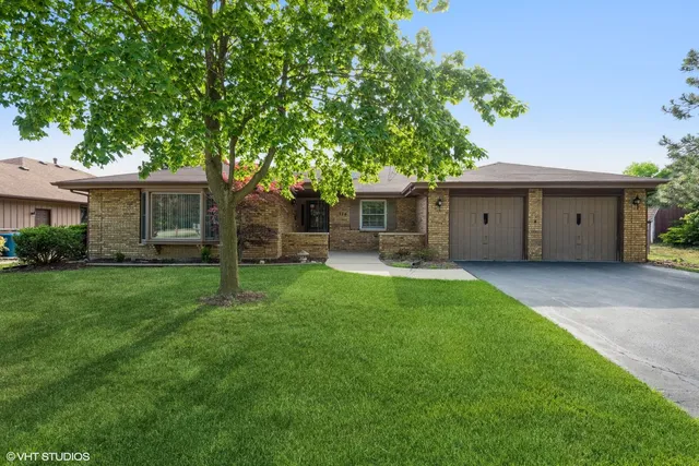 a front view of house with a garden