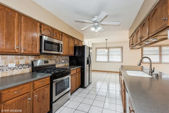 a kitchen with stainless steel appliances granite countertop a stove a sink and a microwave