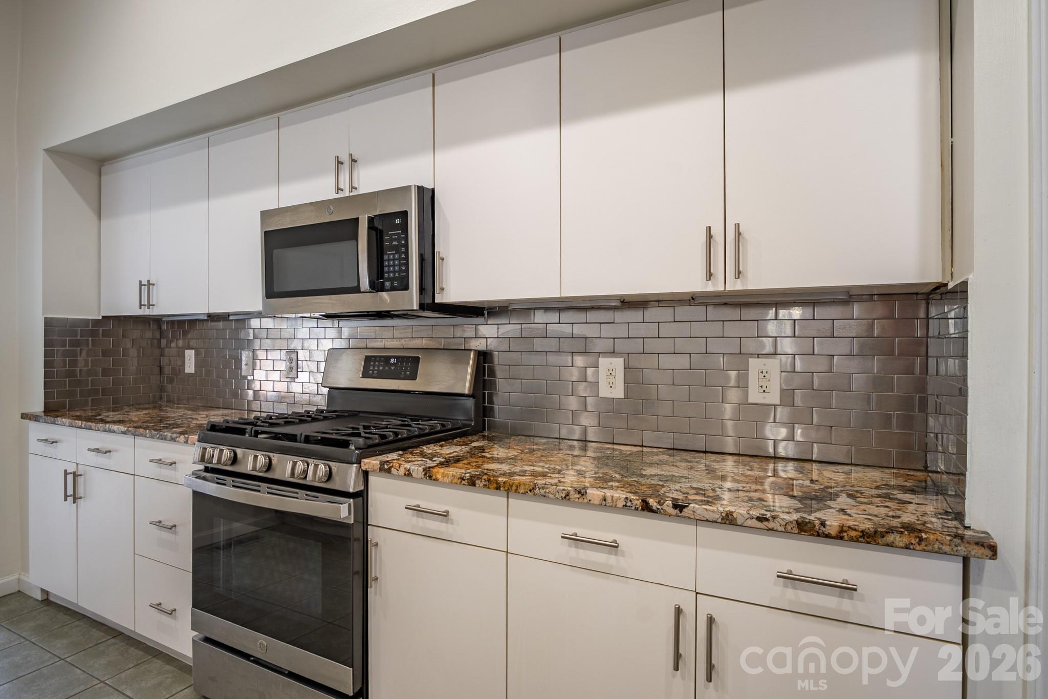 208 Island View Road Mount Holly, NC 28120 - Photo 12 of 37 a kitchen with granite countertop a stove a sink and a microwave