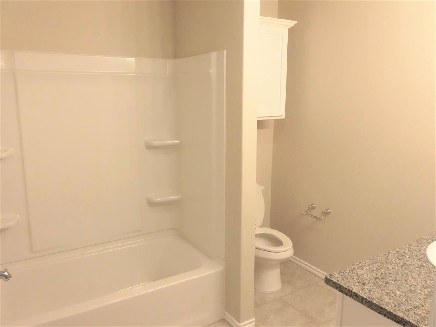 3712 Prentiss Avenue Lubbock, TX 79407 - Photo 9 of 23 a bath room with a toilet and a bath tub