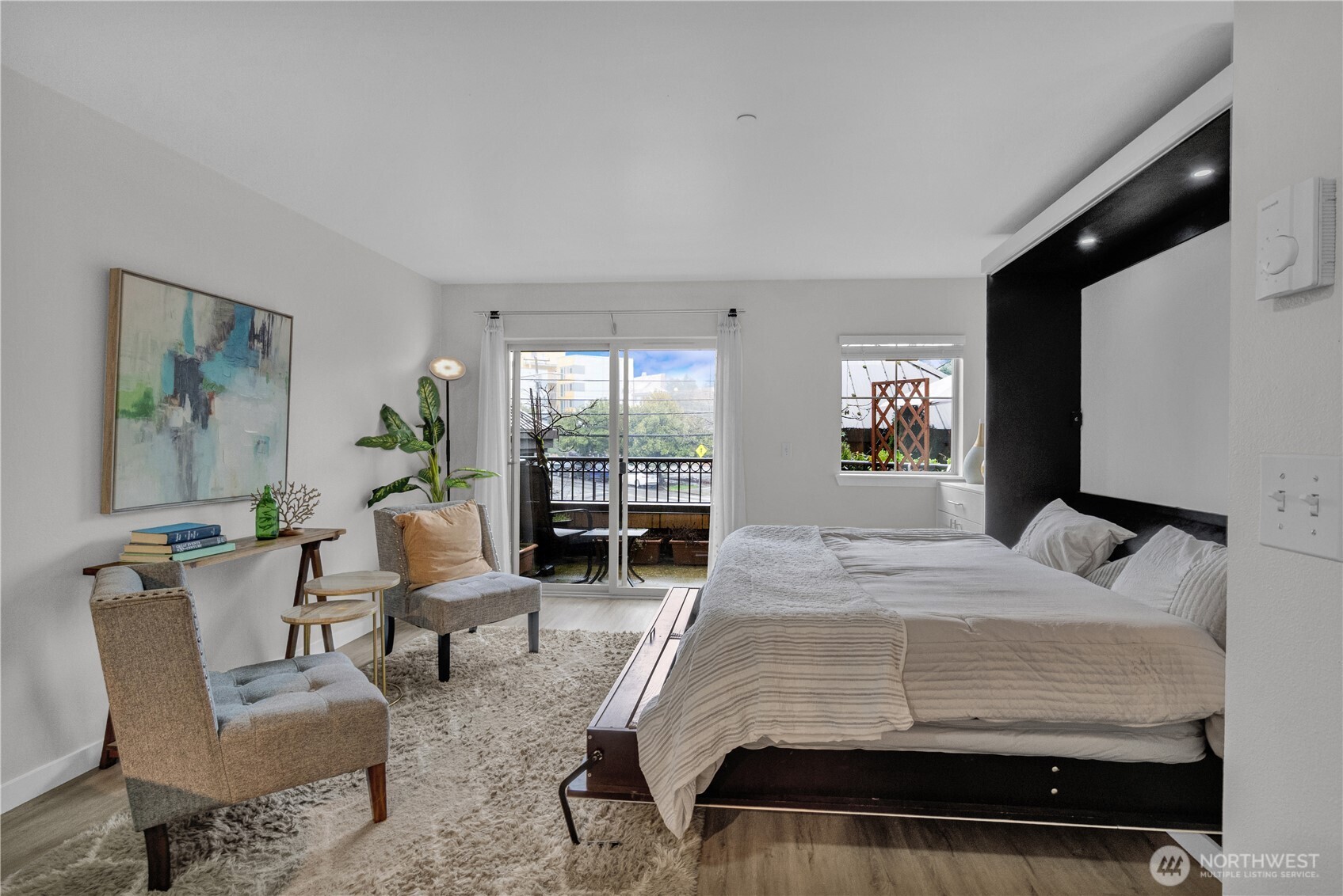 1125 East Olive Street, Unit 212 Seattle, WA 98122 - Photo 13 of 39 a bedroom with a bed and glass windows