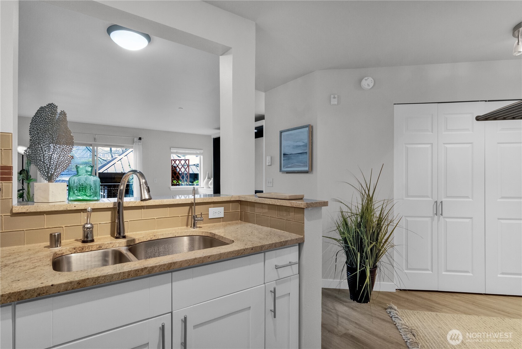 1125 East Olive Street, Unit 212 Seattle, WA 98122 - Photo 16 of 39 a white kitchen with sink and potted plant