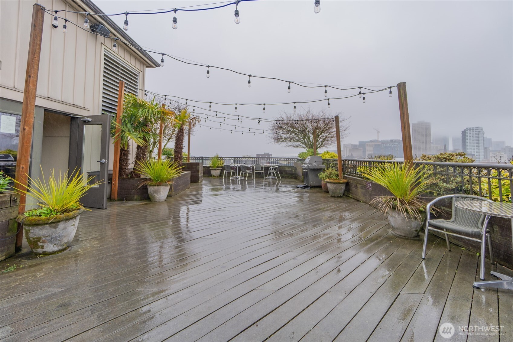 1125 East Olive Street, Unit 212 Seattle, WA 98122 - Photo 38 of 39 a view of a patio with table and chairs with wooden floor