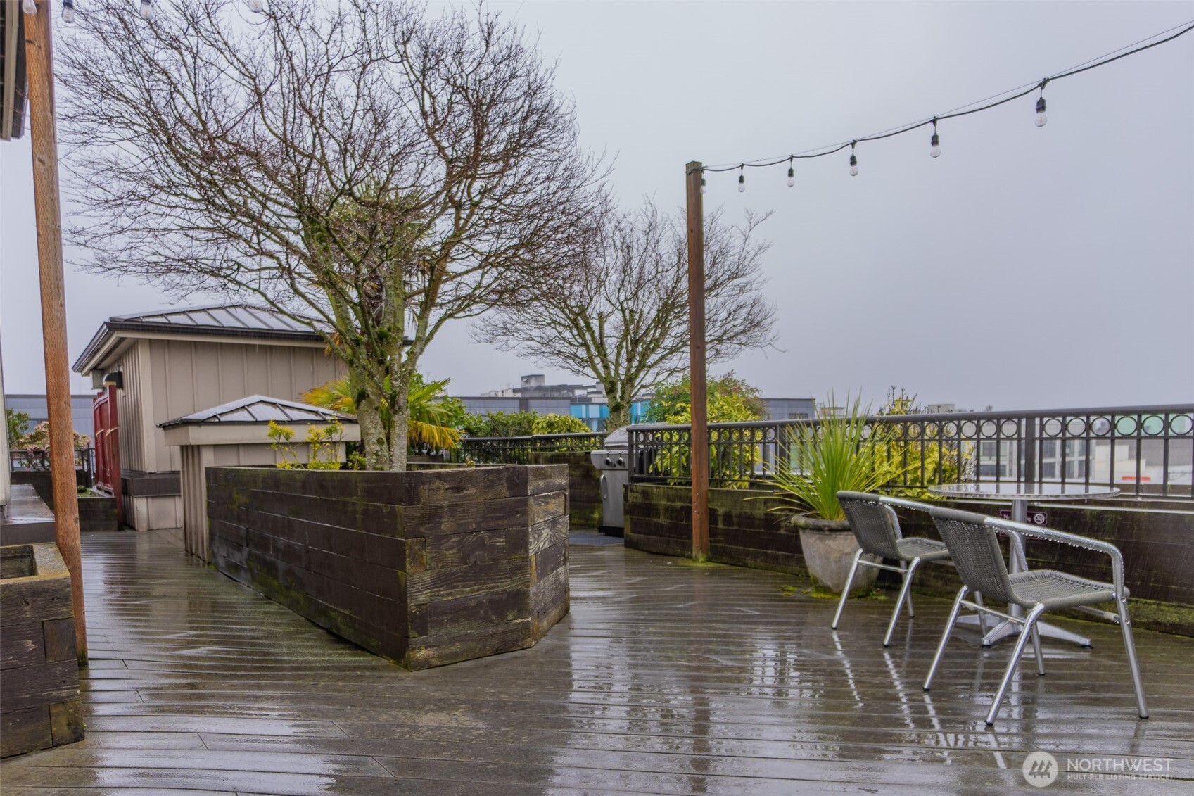 1125 East Olive Street, Unit 212 Seattle, WA 98122 - Photo 39 of 39 a view of a patio with table and chairs with wooden floor and fence