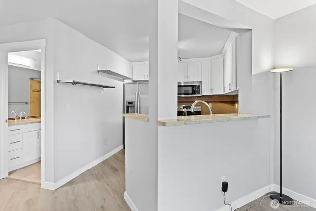 a kitchen with white cabinets and stainless steel appliances