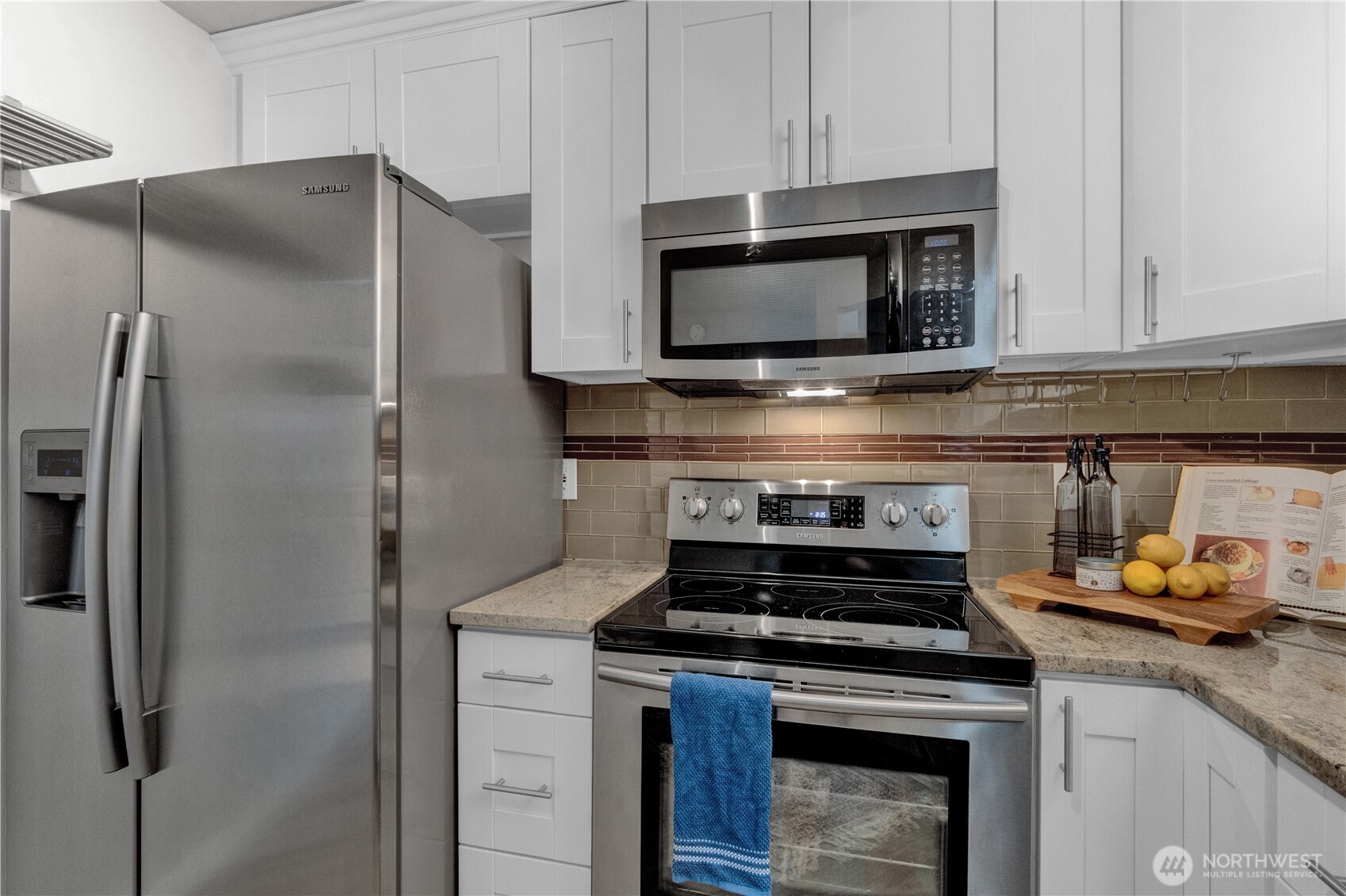 1125 East Olive Street, Unit 212 Seattle, WA 98122 - Photo 8 of 39 a kitchen with stainless steel appliances a stove a microwave and a refrigerator