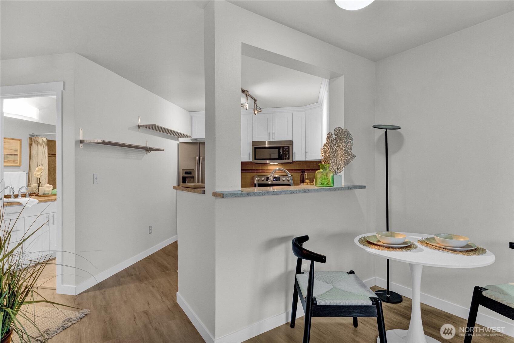 1125 East Olive Street, Unit 212 Seattle, WA 98122 - Photo 9 of 39 a kitchen with stainless steel appliances kitchen island a table chairs in it and wooden floor