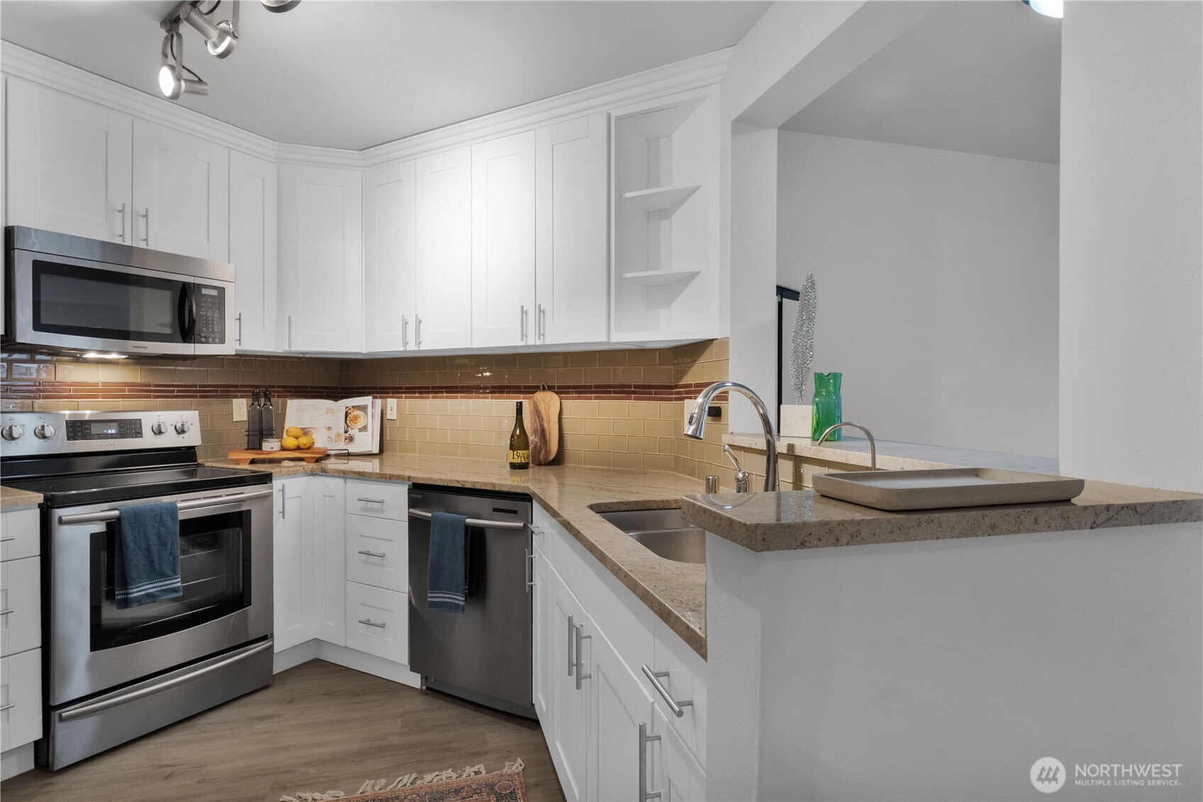 1125 East Olive Street, Unit 212 Seattle, WA 98122 - Photo 10 of 39 a kitchen with stainless steel appliances granite countertop a sink and stove top oven