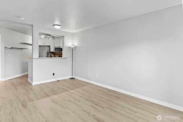 a view of a kitchen with wooden floor and electronic appliances