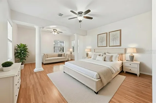 a view of empty room with wooden floor and fan