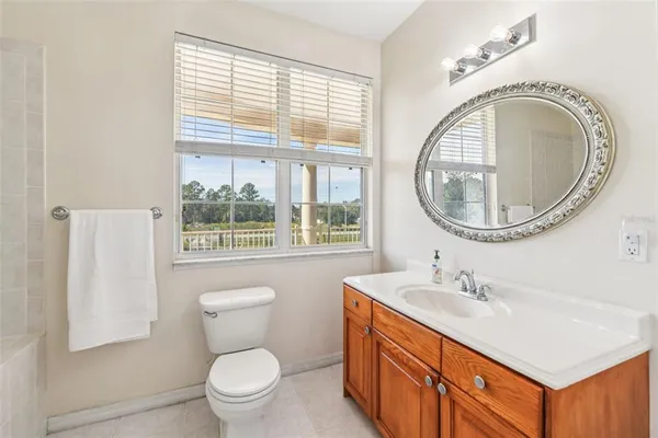 a white bath tub sitting next to a white sink and vanity