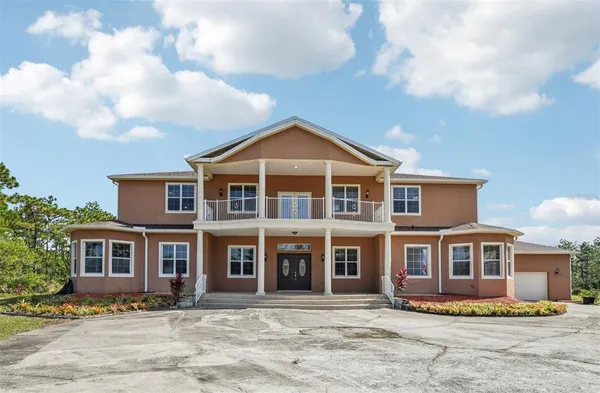 a view of a big house with a big yard and potted plants