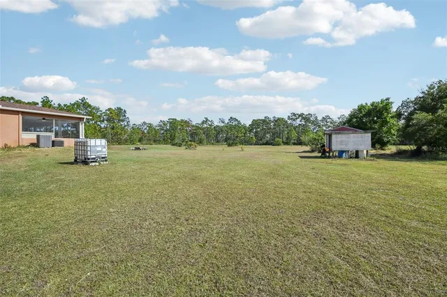a front view of a house with a yard and lake view