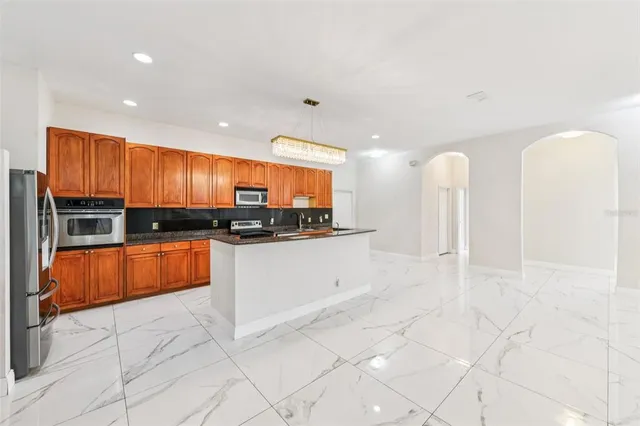 a kitchen with stainless steel appliances granite countertop a sink and a stove