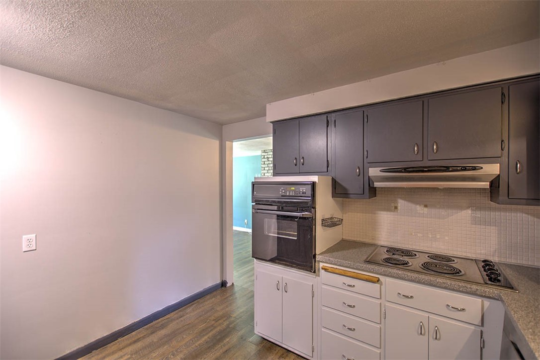 2133 East Moore Street Decatur, IL 62521 - Photo 9 of 26 a kitchen with wooden cabinets and a stove top oven