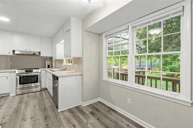 a kitchen with a stove a sink and a window