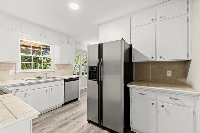 a kitchen with a refrigerator sink and cabinets