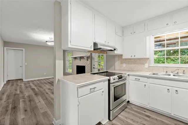 a kitchen with a stove a sink and a microwave