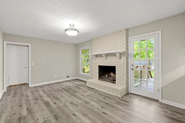 a view of an empty room with a fireplace and a window