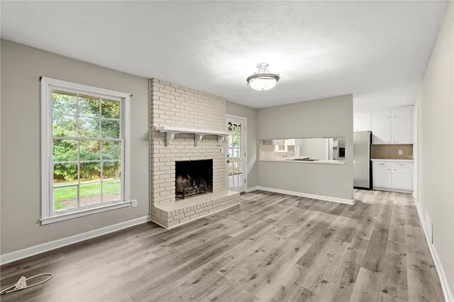 a view of empty room with a fireplace and wooden floor
