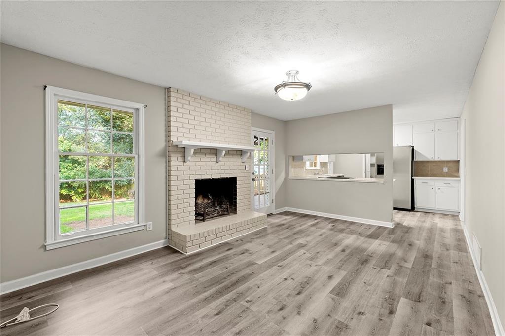 410 Milton Avenue Alpharetta, GA 30009 - Photo 17 of 42 a view of empty room with a fireplace and wooden floor