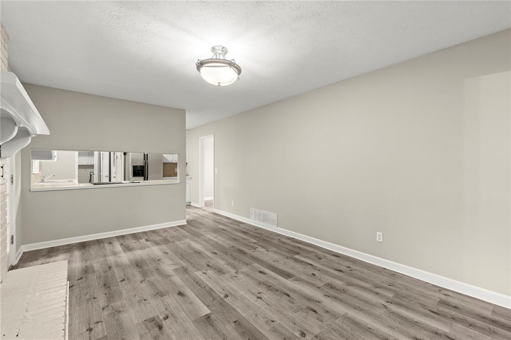 410 Milton Avenue Alpharetta, GA 30009 - Photo 18 of 42 a view of kitchen and empty room with wooden floor