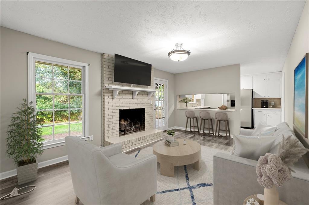 410 Milton Avenue Alpharetta, GA 30009 - Photo 2 of 42 a living room with furniture a fireplace and a flat screen tv