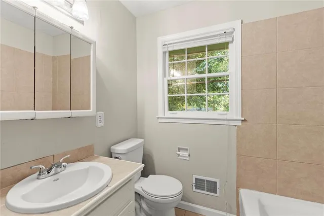 a bathroom with a sink a toilet and a mirror