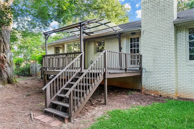 a view of a house with a yard and wooden deck