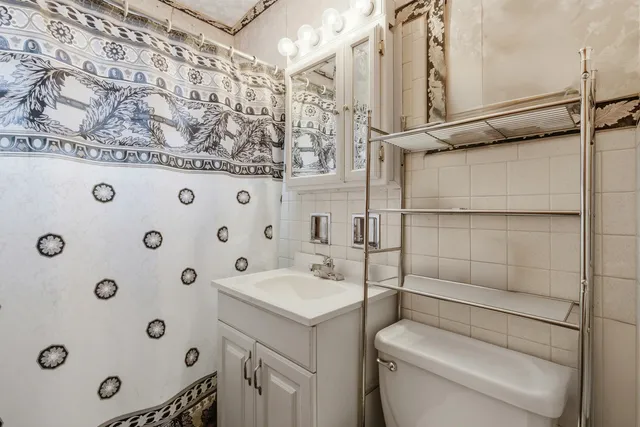 a bathroom with a granite countertop sink a toilet and shower