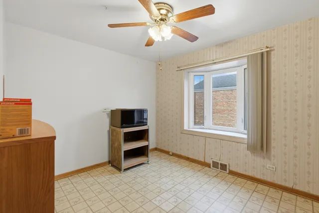 an empty room with windows and ceiling fan
