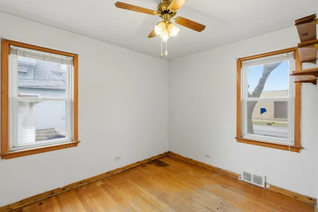 a view of empty room with window and wooden floor