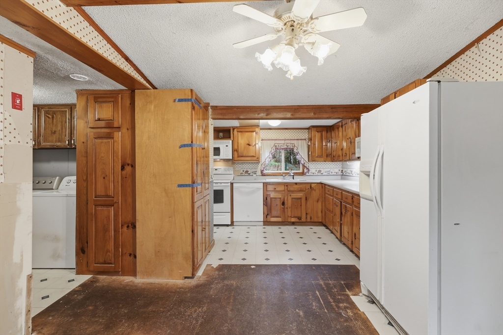 987 Patriots Road Templeton, MA 01468 - Photo 14 of 39 a kitchen with a refrigerator a sink and dishwasher with white cabinets