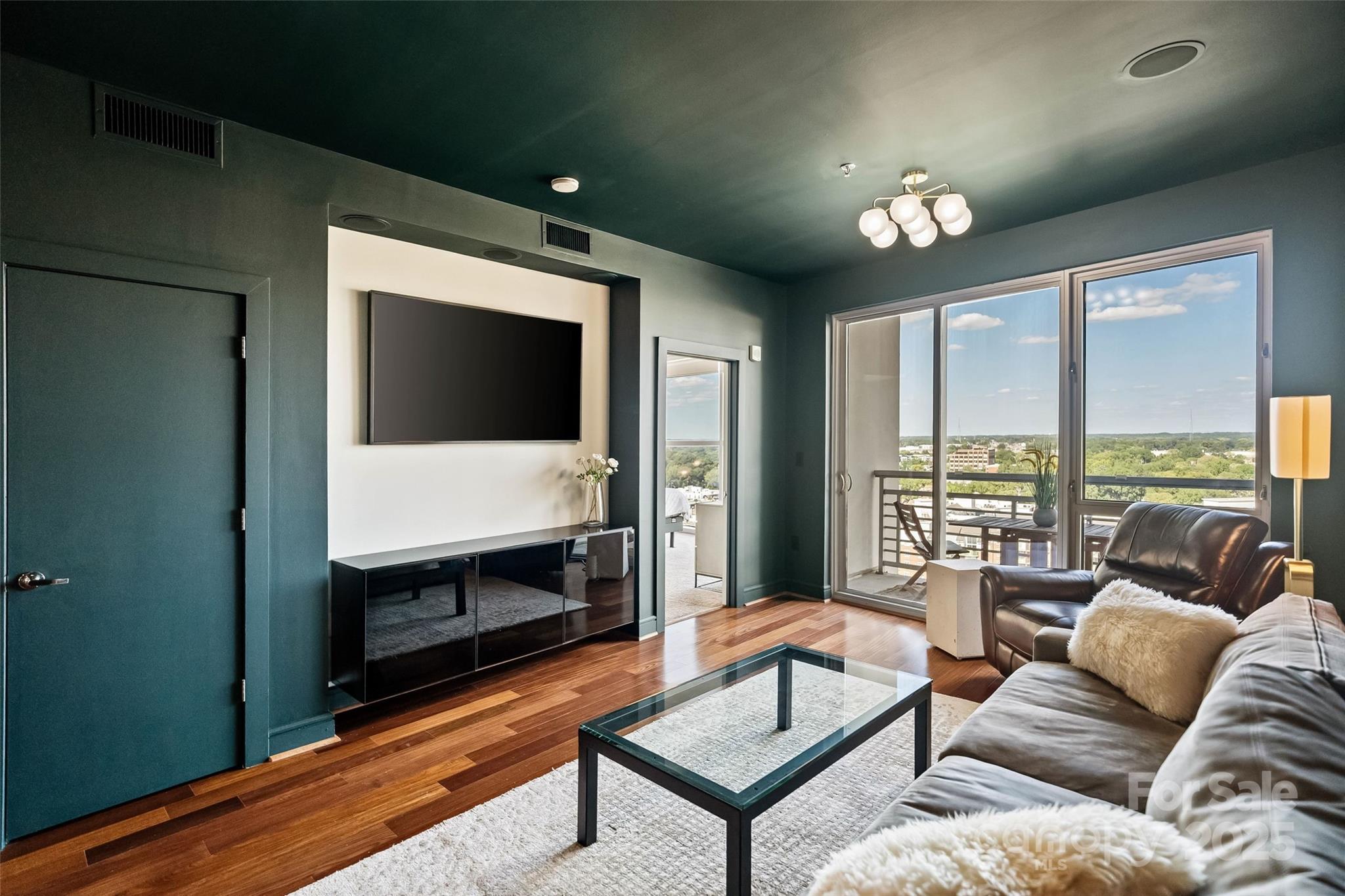 333 West Trade Street, Unit 1301 Charlotte, NC 28202 - Photo 11 of 34 a living room with furniture and a flat screen tv