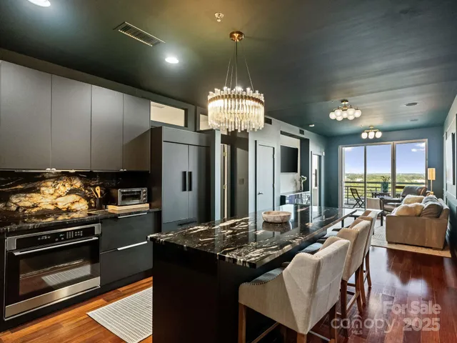 a kitchen with kitchen island granite countertop a stove and a refrigerator