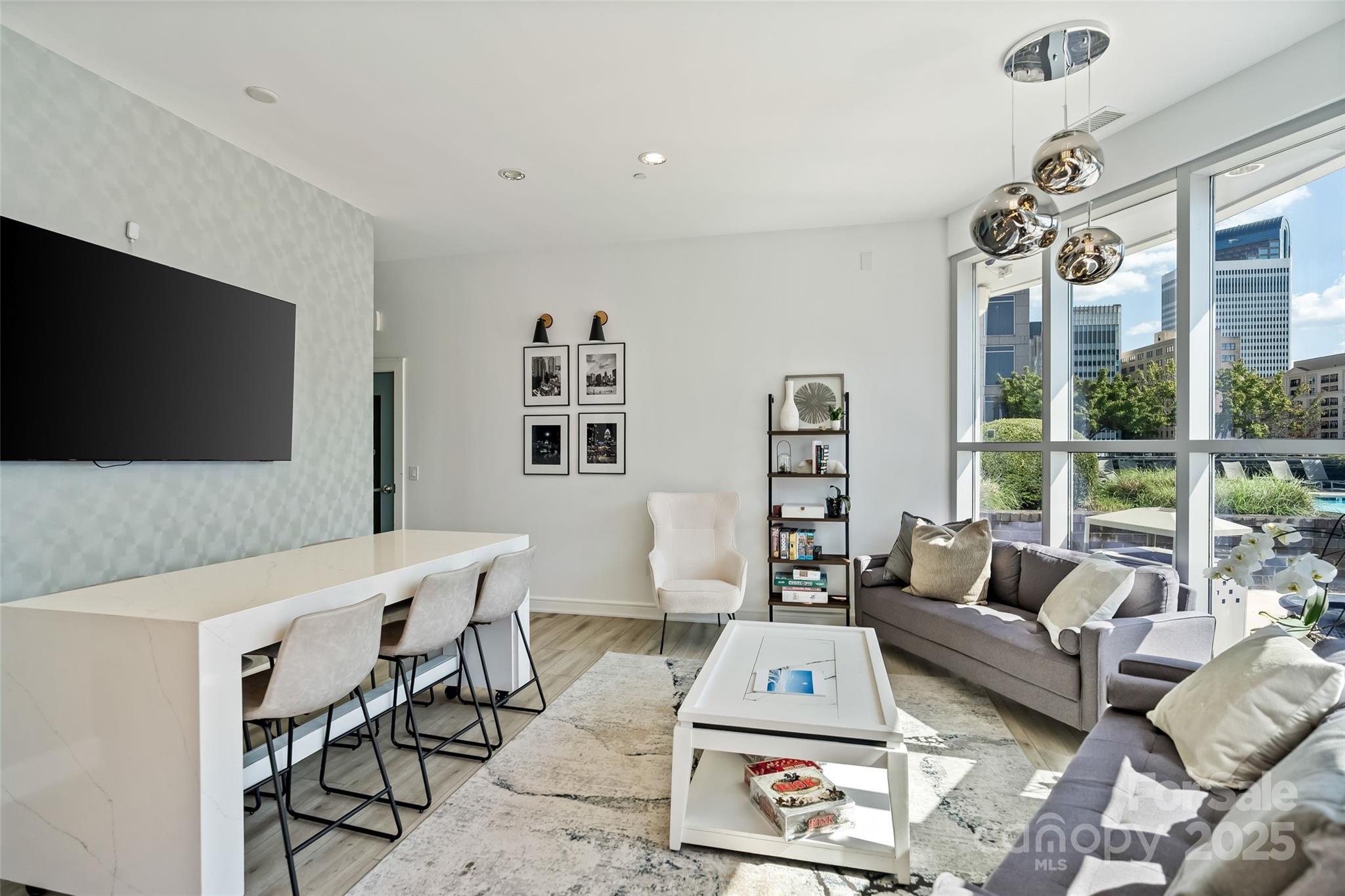 333 West Trade Street, Unit 1301 Charlotte, NC 28202 - Photo 33 of 34 a living room with furniture a flat screen tv and a floor to ceiling window