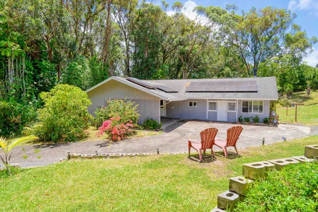 a view of a house with a yard patio and fire pit