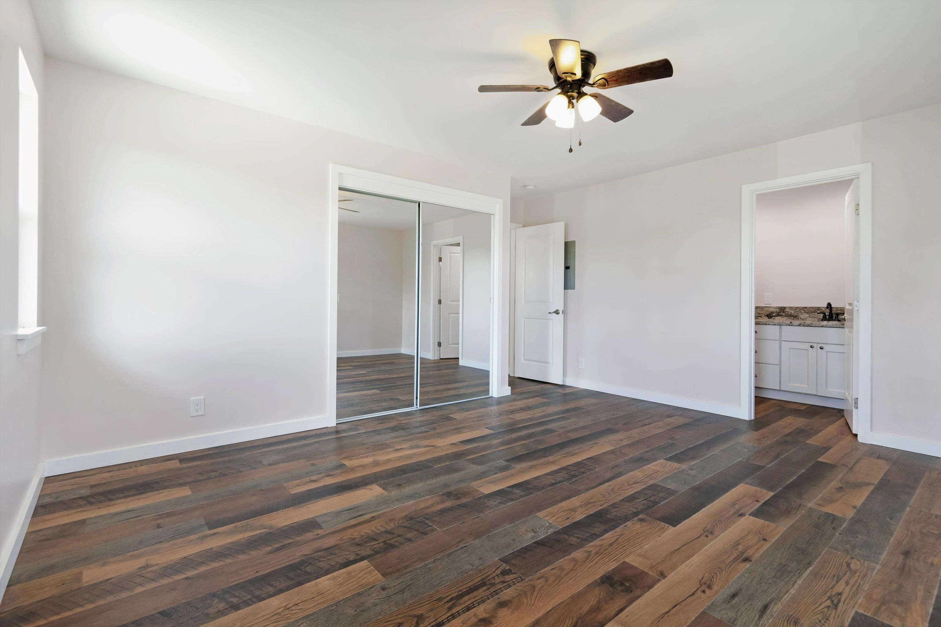 605 Kaupakalua Road Haiku, HI 96708 - Photo 20 of 44 an empty room with wooden floor and a ceiling fan