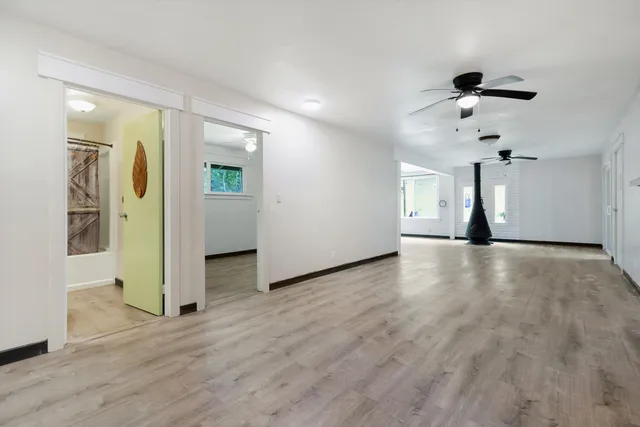 a view of a livingroom with wooden floor and a ceiling fan