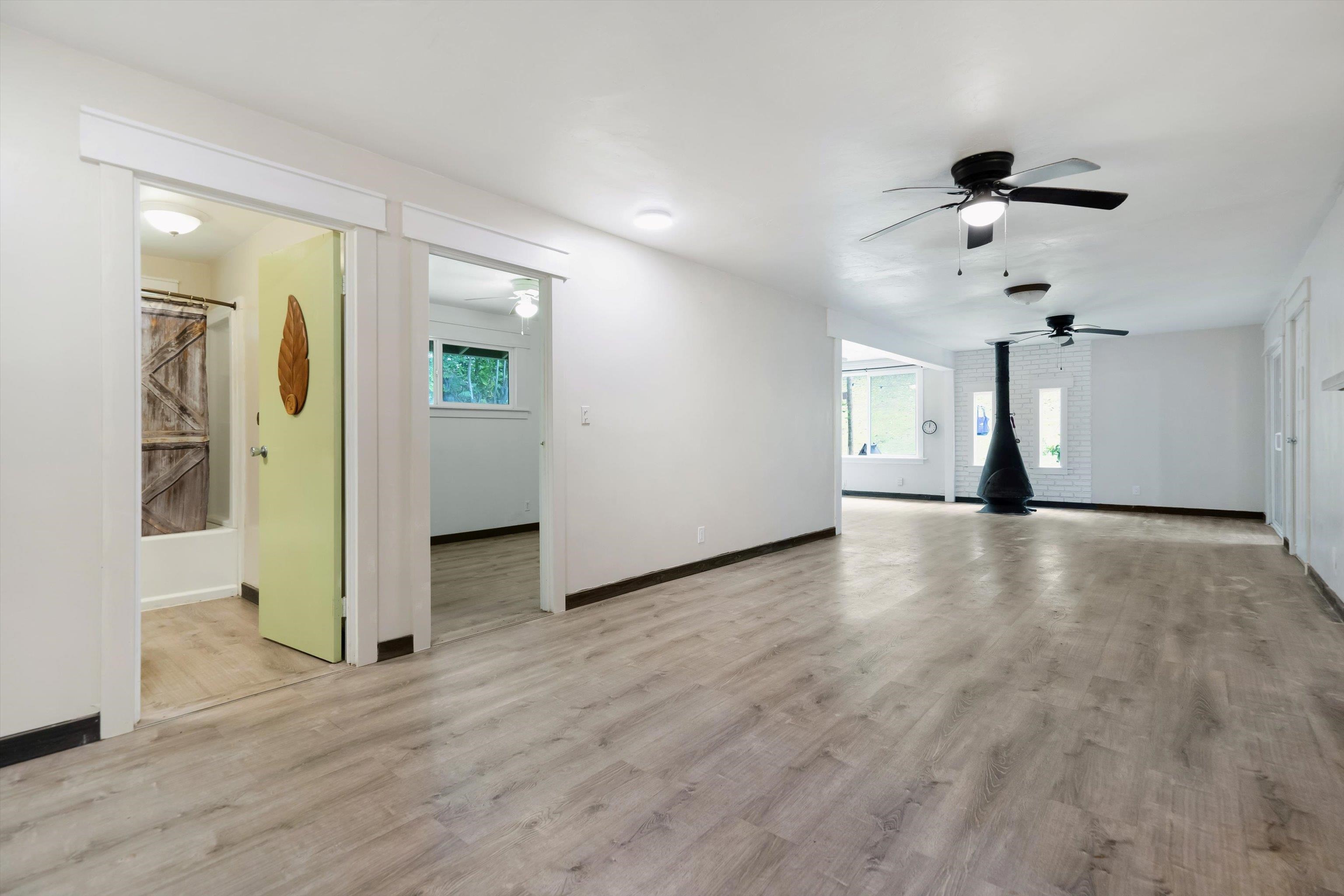 605 Kaupakalua Road Haiku, HI 96708 - Photo 30 of 44 a view of a livingroom with wooden floor and a ceiling fan