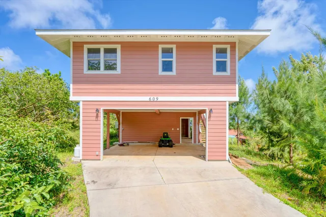 a view of a house with potted plants and a table and chairs