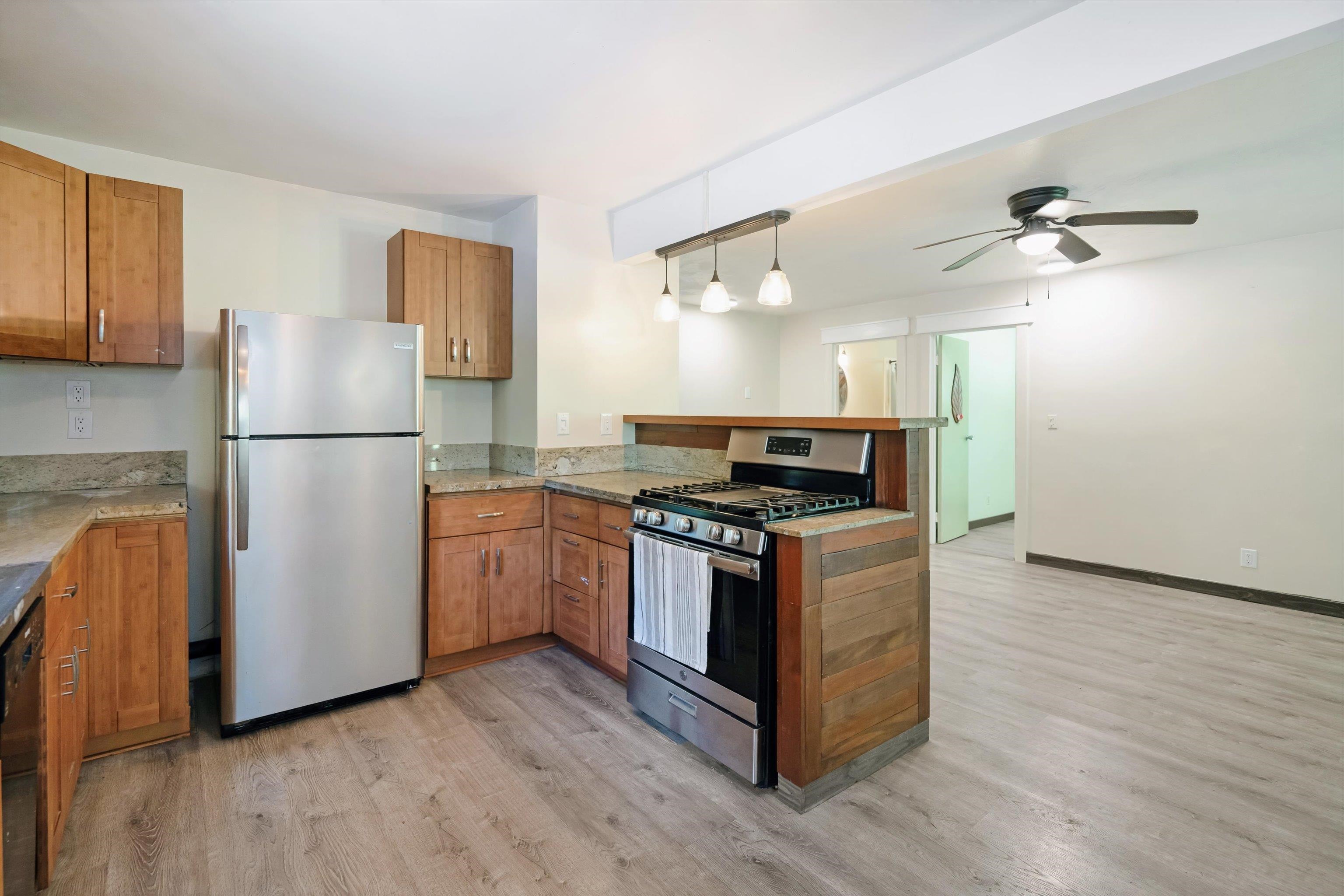 605 Kaupakalua Road Haiku, HI 96708 - Photo 34 of 44 a kitchen with a refrigerator stove and wooden cabinets