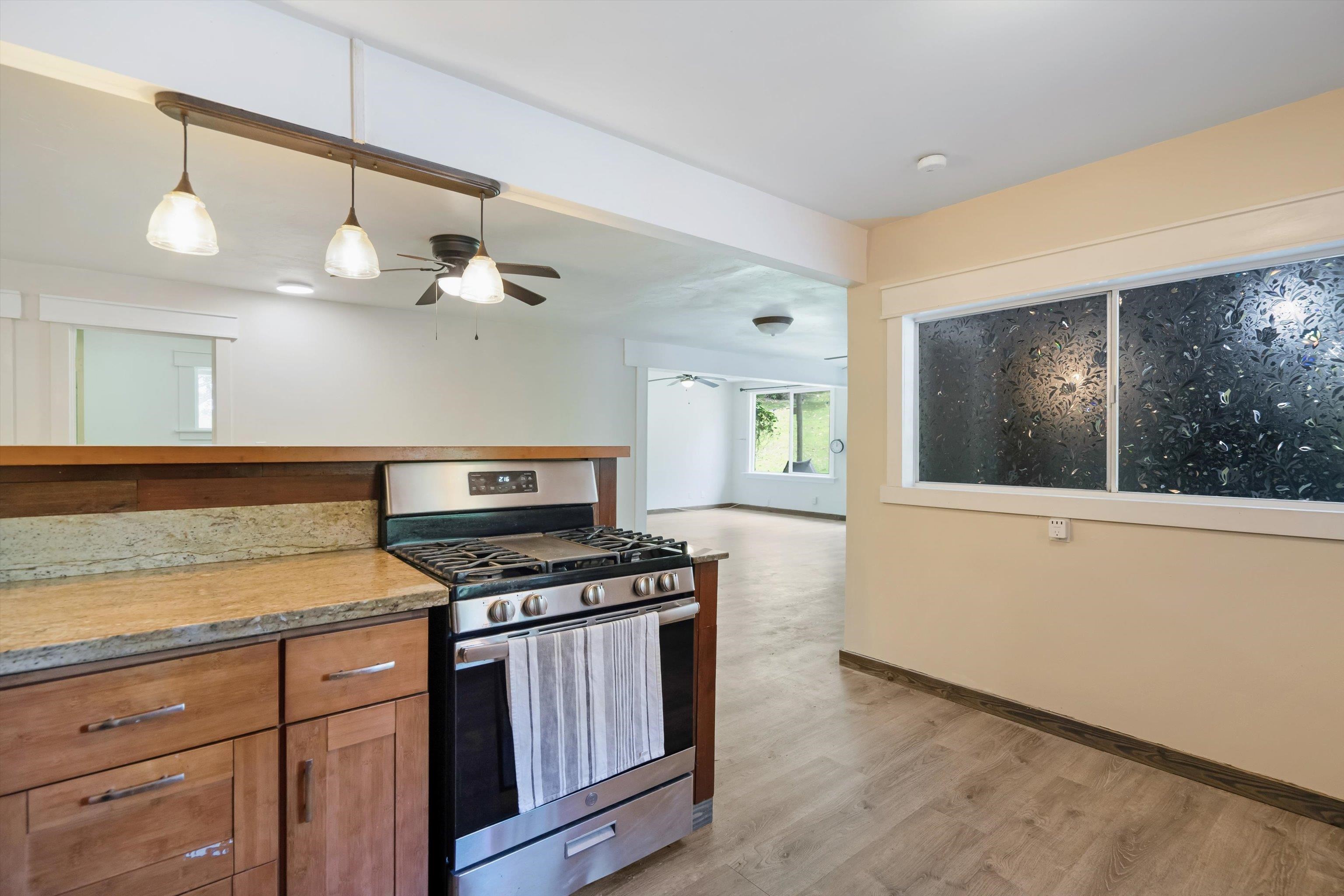 605 Kaupakalua Road Haiku, HI 96708 - Photo 36 of 44 a kitchen with stainless steel appliances granite countertop a stove a sink and a microwave