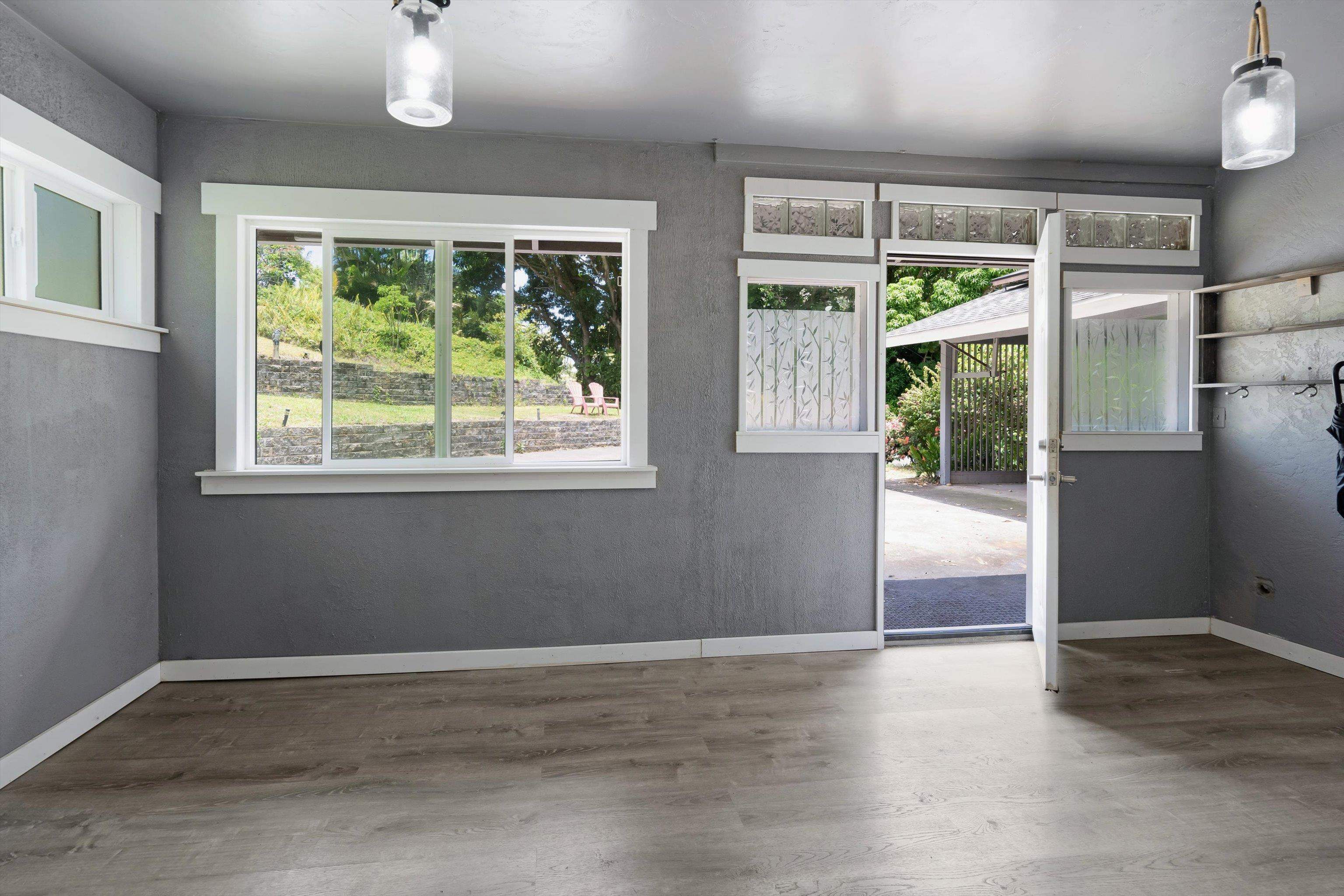 605 Kaupakalua Road Haiku, HI 96708 - Photo 38 of 44 a view of an empty room with wooden floor and a window