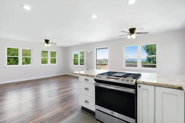 a kitchen with granite countertop a stove and a sink