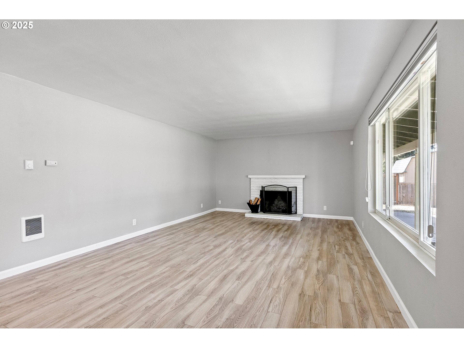 620 Nottingham Avenue Eugene, OR 97404 - Photo 5 of 36 a view of an empty room with wooden floor and a window
