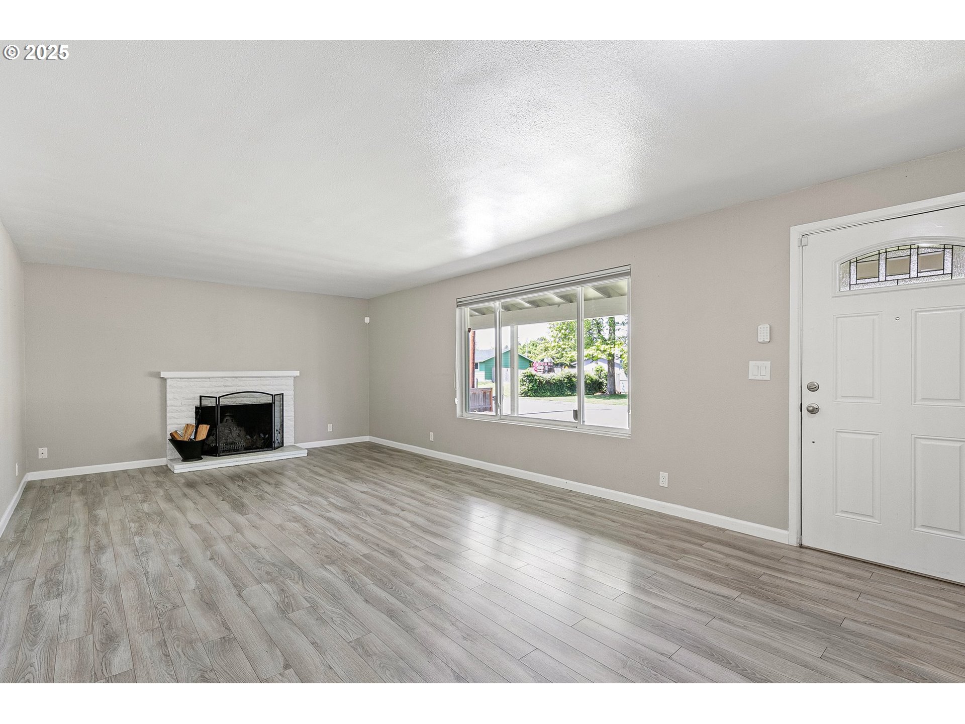620 Nottingham Avenue Eugene, OR 97404 - Photo 10 of 36 an empty room with wooden floor and fireplace