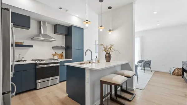 a kitchen with stainless steel appliances granite countertop a sink a stove and a refrigerator