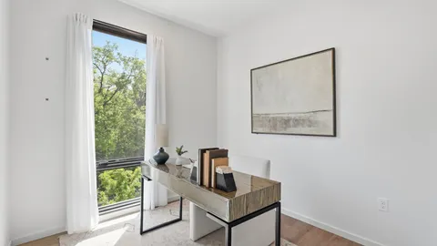 a view of a workspace with furniture and a window